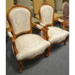 A pair of white upholstered French style open armchairs