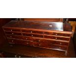 An unusual mahogany small chest with hinged lid and an arrangement of drawers