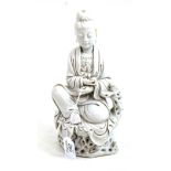 A Blanc de Chine figure of Guanyin, Qing Dynasty, sitting on a root work throne, impressed marks,