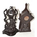 A small treen watch stand, depicting two cherubs holding an urn of flowers, 30cm high, a carved
