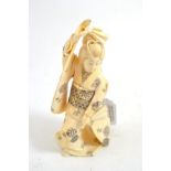 A Japanese ivory okimono, circa 1900, depicting a lady holding a fan, 14cm high Missing part of fan,