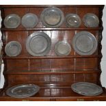 Nine large pewter plates and seventeen smaller examples