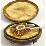 A garnet and seed pearl mourning brooch, a locket panel within a border of split pearls to an