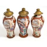 A set of three Chinese porcelain baluster vases, Qianlong, painted in famille rose enamels with