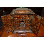 An ornamental faux wood sewing box, mid Victorian with cupboard doors, height 32cm