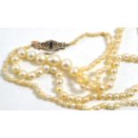 A cultured pearl necklace with a sapphire and diamond clasp, the graduated pearls knotted to the