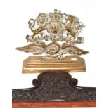 A brass door stop circa 1897, cast with the Royal arms supported by an eagle on a stepped