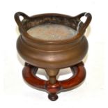 A Chinese bronze censer on three feet with loop handles, bears six character reign mark, 16.5cm