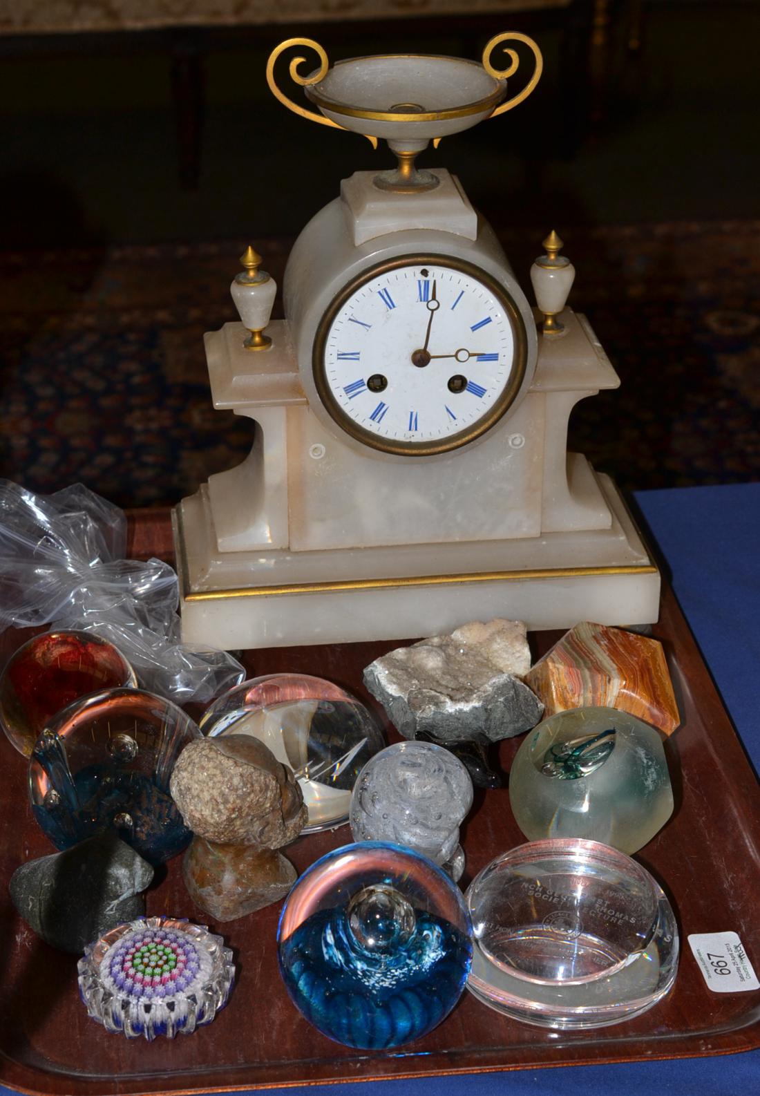 An alabaster striking mantel clock and a quantity of paperweights, 3-inch enamel dial, twin barrel