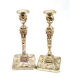 A matched pair of Neo Classical style silver candlesticks decorated with typical rams' heads and