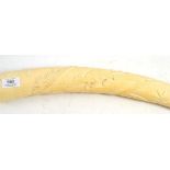 An ivory tusk, circa 1900, carved with animals and foliage, 68cm wide  Heavy damage/ hairlines at