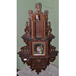 A Diamond Jubilee fret carved hanging wall cupboard, 1897, the mirrored door with a bust portrait of