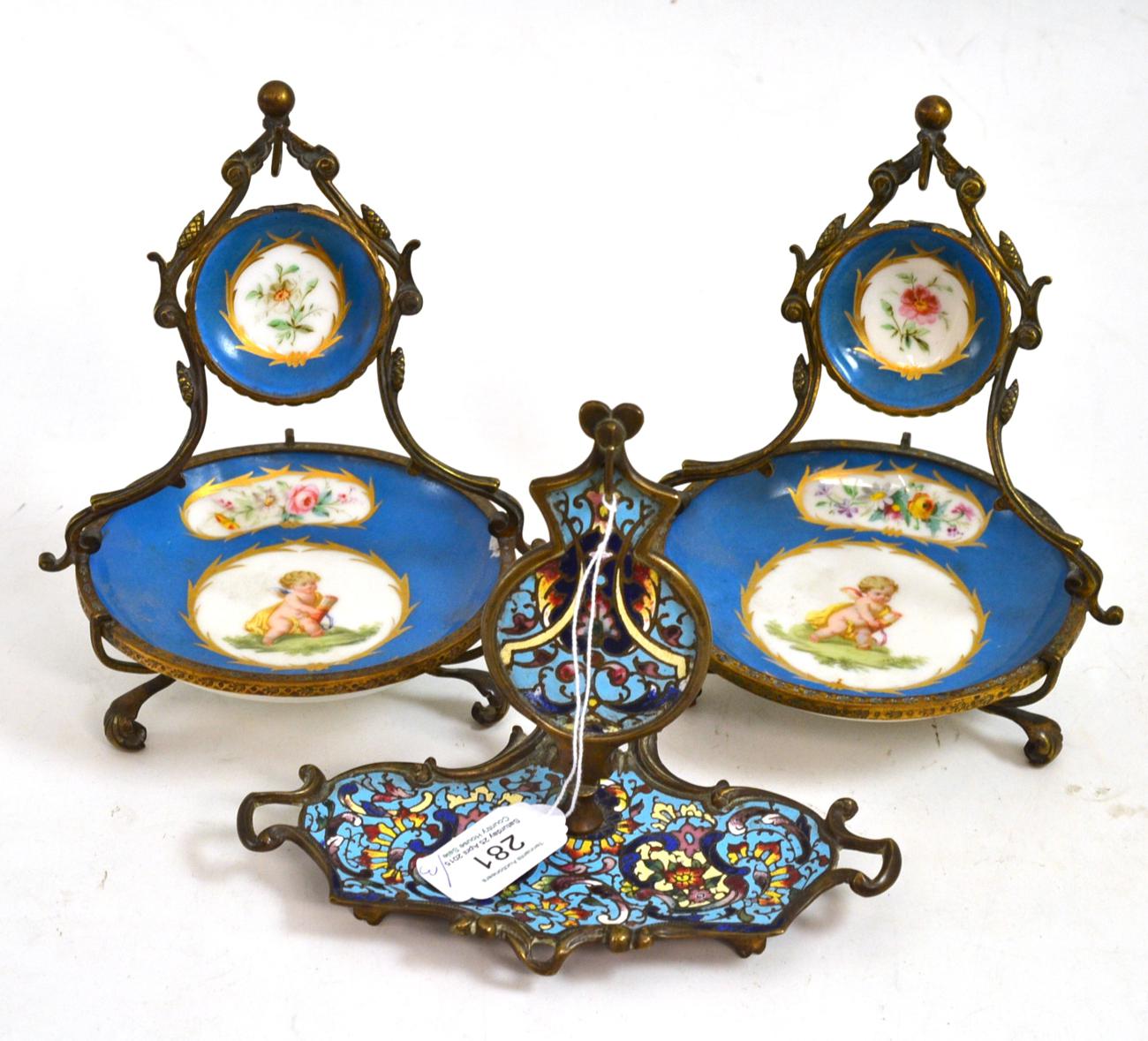 A champleve watch stand, 13cm high, and a pair of Sevres-style watch stands, 16cm high Damage