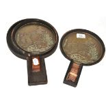 A pair of Japanese bronze hand mirrors in wooden case  Wear to handles and polished to high relief