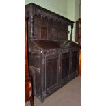 An 18th century large oak dresser with two hinged sloping doors to the top and rack with carved