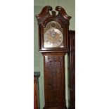 An oak eight day longcase clock, carved case with a swan neck pediment, 12-inch arched brass dial,