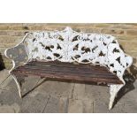 A Coalbrookdale style cast iron fern bench, white painted with wooden slat seat, on foliate sheathed