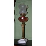 Brass oil lamp with cranberry glass reservoir and brass column support, 77cm high