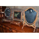 Two George III mahogany toilet mirrors and a later shield shaped toilet mirror