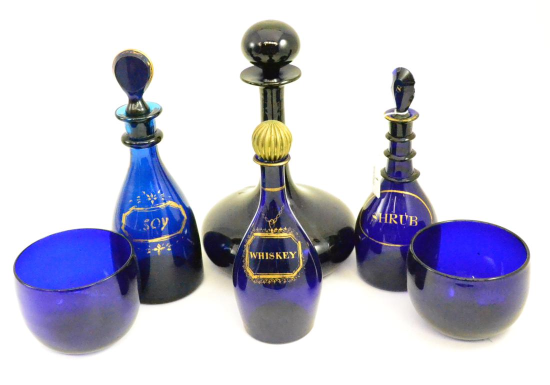 A tray of blue glass comprising of a ships decanter, a soy decanter, a whiskey decanter, a shrub
