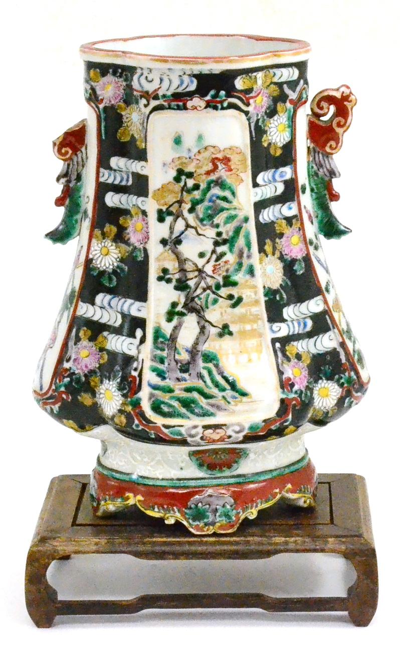 A Chinese famille vert/noir vase on wood stand