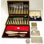 A silver vesta, four cigarette cases, a plated cruet set, a set of fish servers and a cased set of