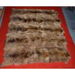 An Animal Skin Mounted Red Wool Car Rug, probably circa 1930, composed of five pelts, possibly of