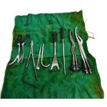 A Roll of Ebony Handled Obstetric Instruments, includes two pairs of craniotomy forceps, delivery
