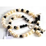 A black spinel and cultured pearl necklace and a pair of earrings