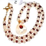 A garnet and cultured pearl necklace with pendant drop, the cultured pearls spaced with faceted