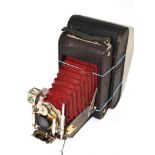 Folding camera with Unicum lens and maroon bellows with plaque 'Boots Cash Chemist Photographic