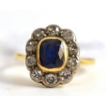 A sapphire and diamond cluster ring, a (scuffed) sapphire within a border of diamonds (total