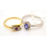 A tanzanite and diamond cluster ring, stamped 'PT 950' and a ruby and diamond three stone twist ring