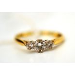 A diamond three stone ring, the graduated round brilliant cut diamonds in white claw settings, to