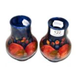 A pair of William Moorcroft Pomegranate pattern vases, on a blue ground, impressed marks and green