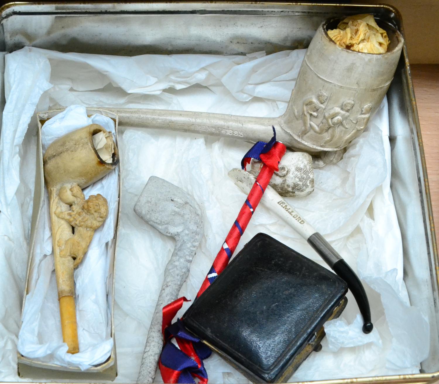 A Jumbo Clay Pipe with Football Scene, together with other clay pipes, including a Kitchener pipe
