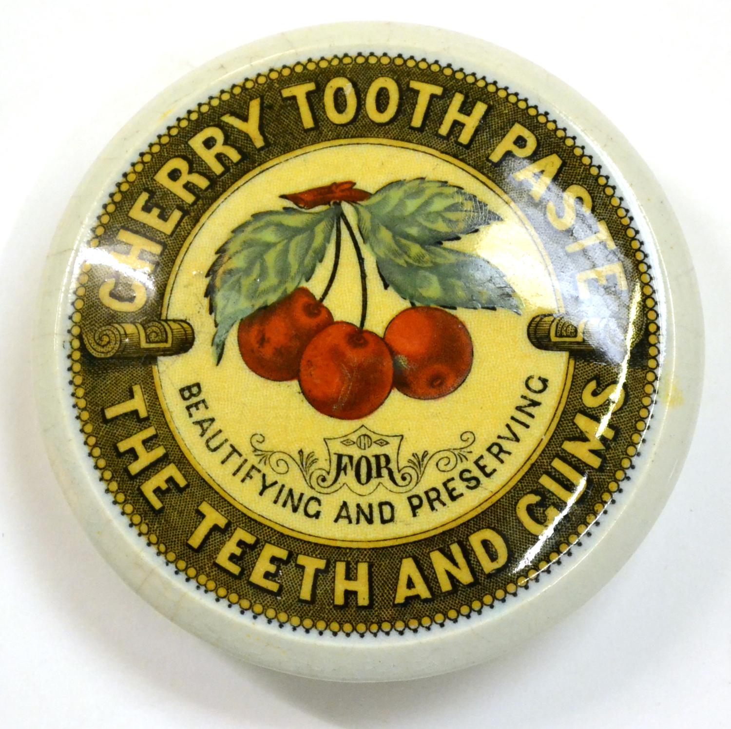 A Coloured Transfer Printed Pictorial Cherry Tooth Paste Pot Lid, with triple cherry trademark