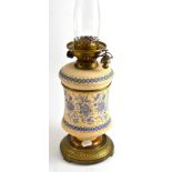 An early 20th century pottery oil lamp with another glass chimney  Rubbing to gilt decoration,