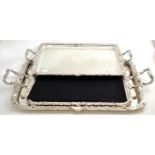 A pair of silver plated tea trays and another larger