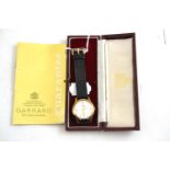 A 9ct gold gents wristwatch, retailed by Garrard, with Garrard box and booklet