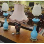 Two blue opaline glass oil lamps and wells with glass chimneys and opaque shades, decorated with