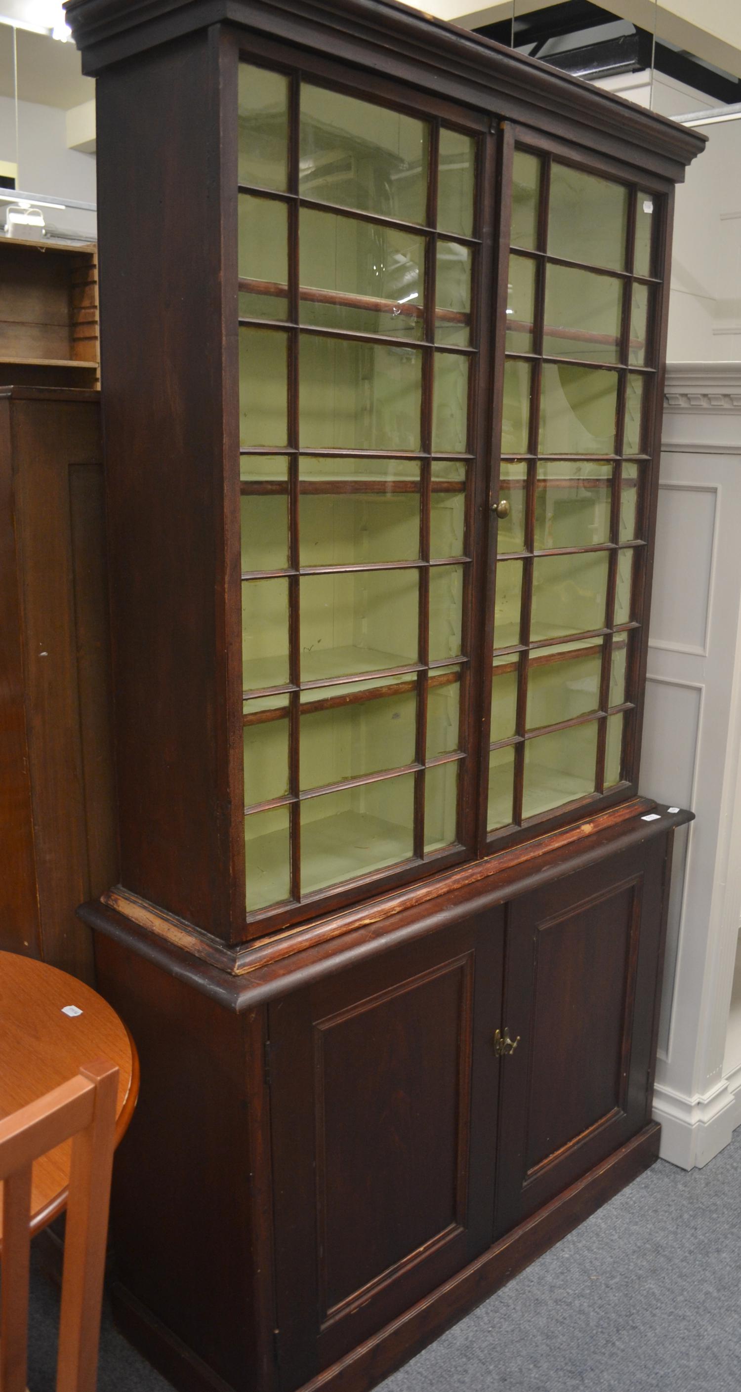 A pine Victorian astragal glazed bookcase on cabinet