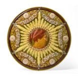 2032 A Linthorpe Pottery Charger, moulded with the profile of a maiden in a sun burst surrounded