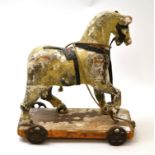 Carved 19th century pull along polychrome horse on rectangular stand with wheels