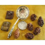 George III silver shilling, a silver sugar sifter spoon, and assorted carved nuts