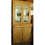 Victorian stripped pine bookcase having upper section with two arch-topped glazed doors above a