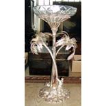 Tall silver plated table centrepiece of an oasis having palm trees & figures, with cut-glass bowl to
