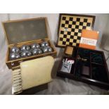 A cased set of boules, a games compendiu