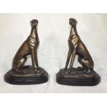 A pair of bronzed figurines depicting gr
