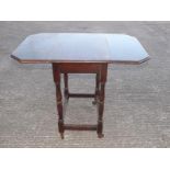 A drop leaf table, the legs terminating